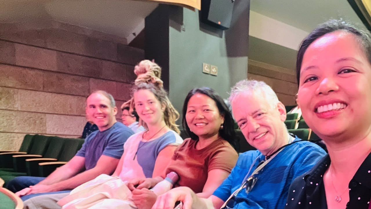 JUC community members sit together in an auditorium.