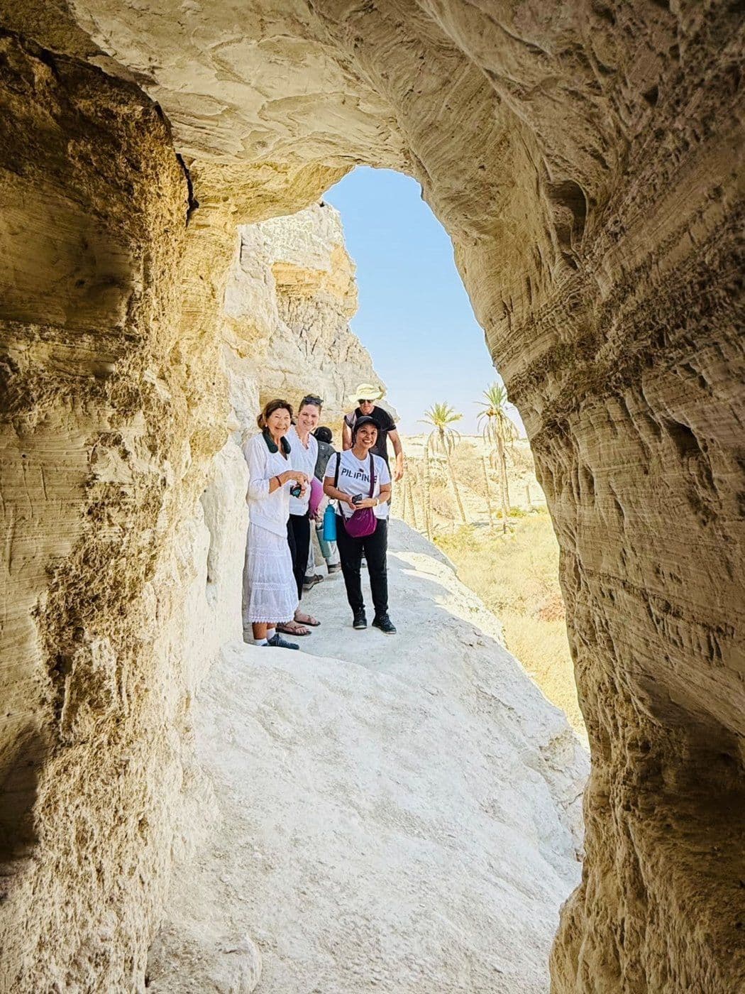 Students stand in a rock-cut passage in the Judean wilderness.