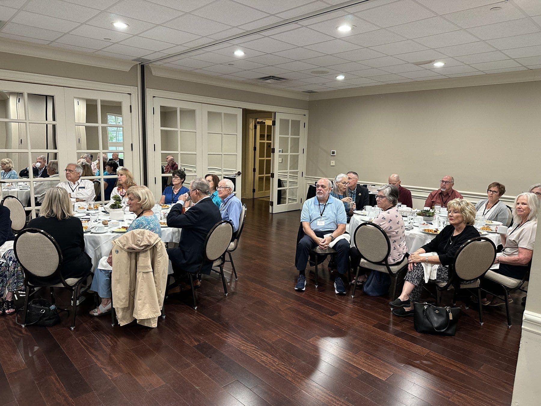 Alumni and supporters sit at tables during a JUC anniversary brunch.