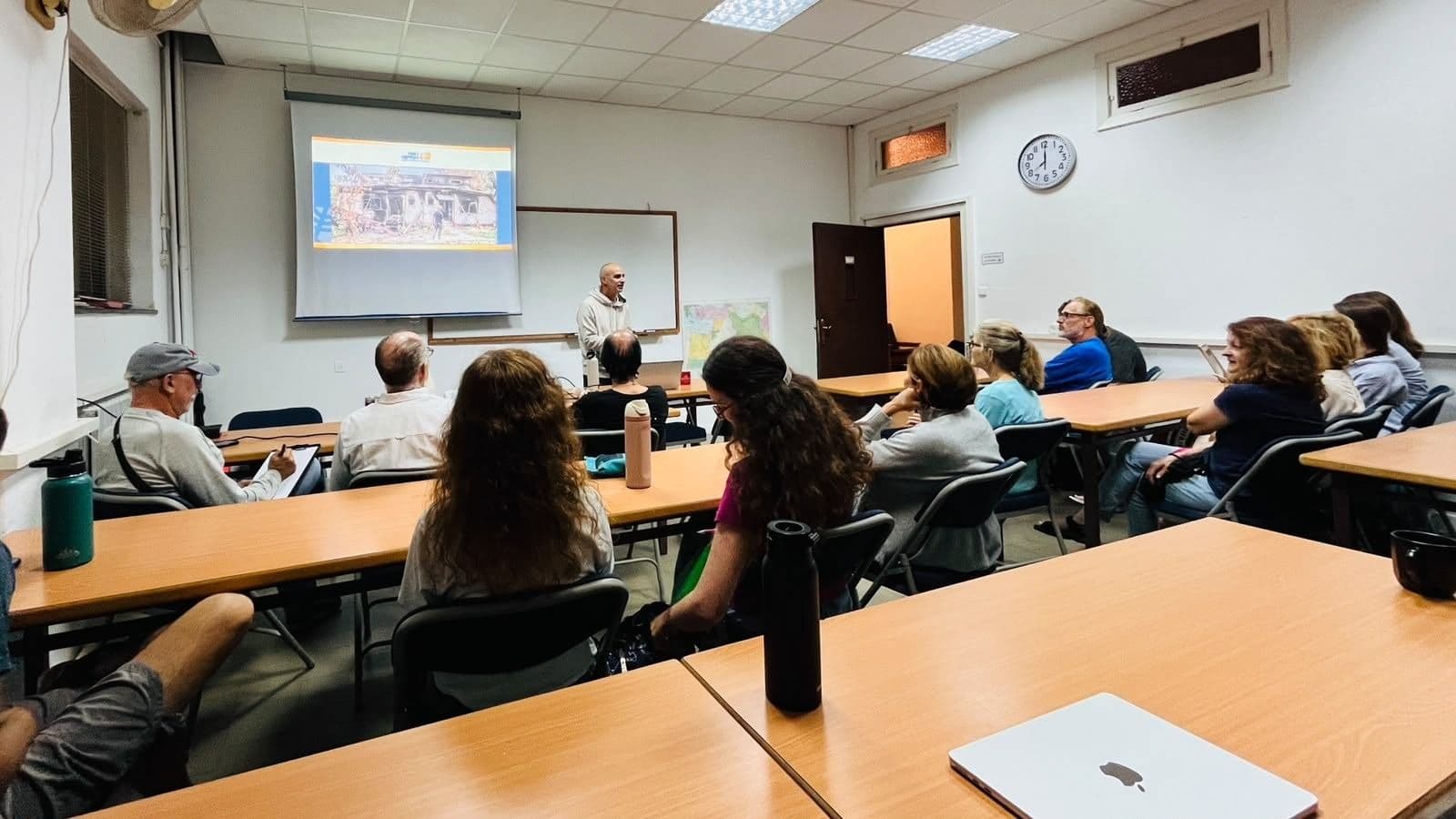 Dr. Joe Uziel presents to an audience seated in a classroom.